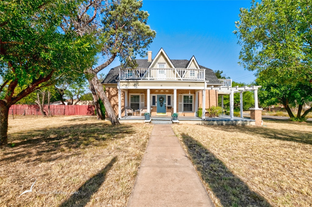 view of front of home featuring a pergola, a front yard, and a porch