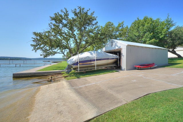 view of vehicle parking featuring a yard and a water view