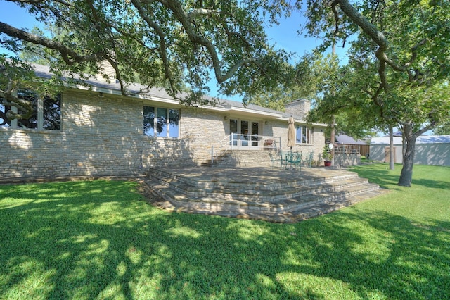 rear view of property with a yard