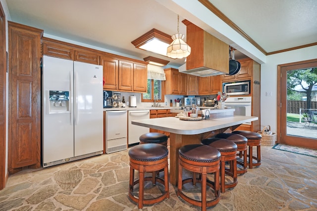 kitchen with pendant lighting, white appliances, a breakfast bar area, and crown molding