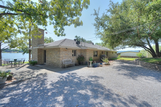 view of front of property with a patio area and a water view