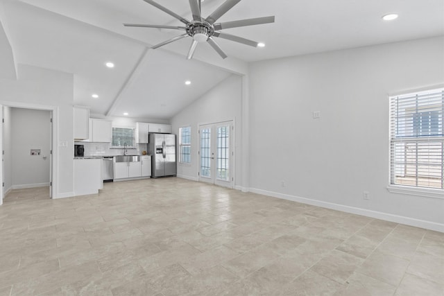 unfurnished living room featuring lofted ceiling with beams, ceiling fan, french doors, and baseboards