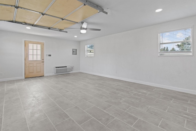 unfurnished room featuring recessed lighting, a wall unit AC, a ceiling fan, and baseboards