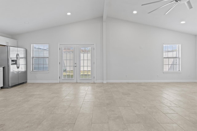 empty room with vaulted ceiling, plenty of natural light, ceiling fan, and french doors