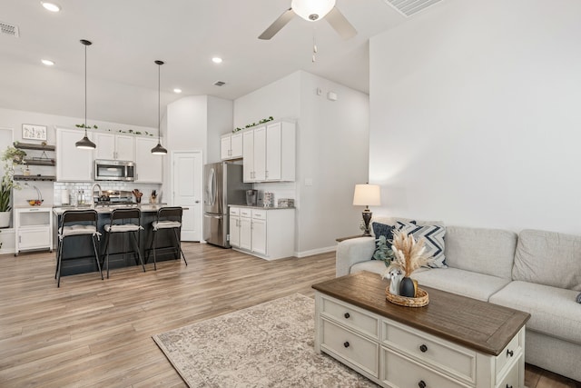 living room featuring ceiling fan and light hardwood / wood-style flooring