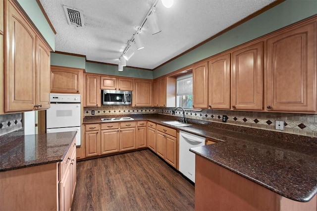 kitchen featuring visible vents, dark wood-type flooring, a sink, white appliances, and crown molding