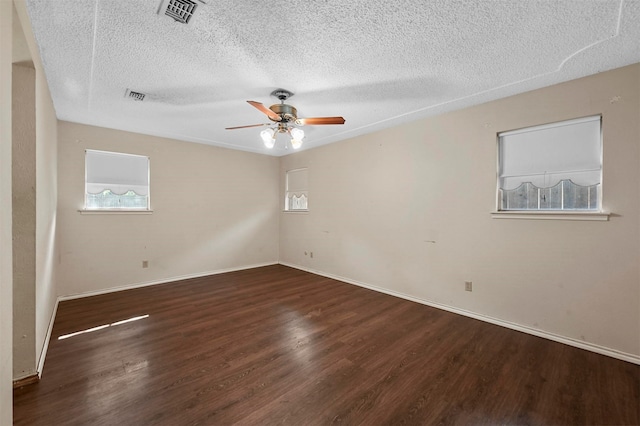 unfurnished room with ceiling fan, dark hardwood / wood-style flooring, and a textured ceiling