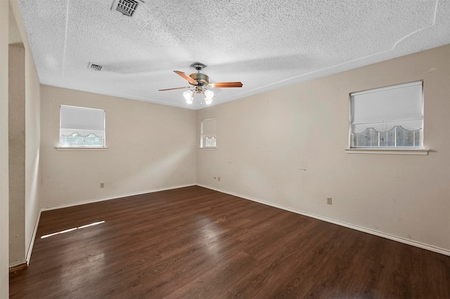 unfurnished room with visible vents, baseboards, ceiling fan, and wood finished floors