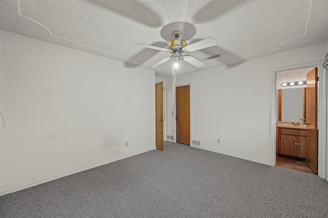 unfurnished bedroom with carpet flooring, visible vents, and a textured ceiling