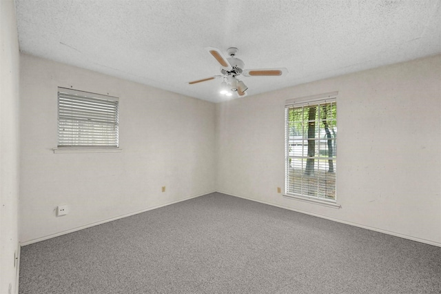 carpeted empty room with baseboards, a textured ceiling, and a ceiling fan