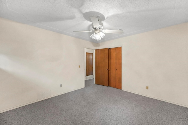 empty room with visible vents, baseboards, carpet floors, a textured ceiling, and a ceiling fan