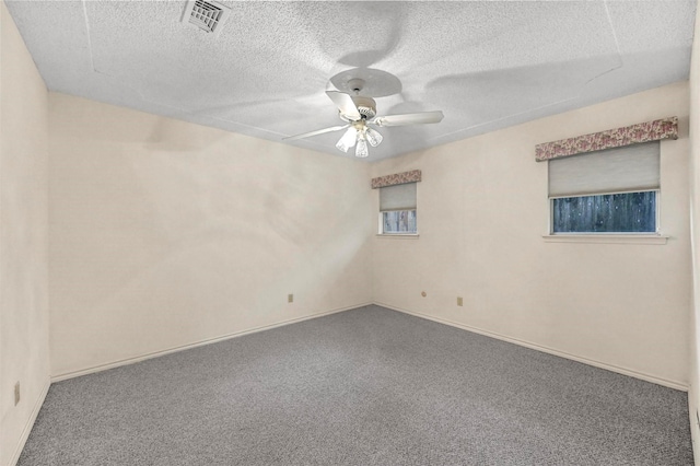 empty room with baseboards, visible vents, ceiling fan, a textured ceiling, and carpet flooring