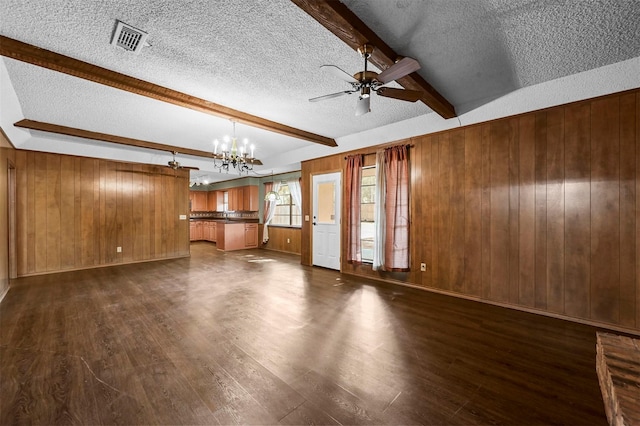 unfurnished living room with beamed ceiling, dark wood-style floors, visible vents, and wood walls