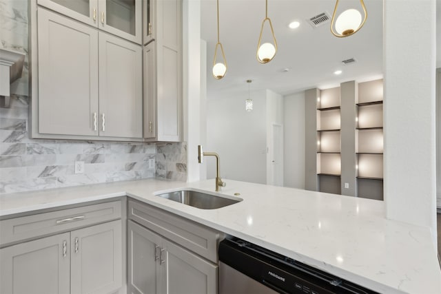 kitchen with light stone countertops, sink, backsplash, and decorative light fixtures