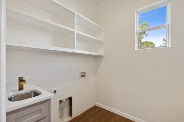 clothes washing area featuring electric dryer hookup, sink, dark hardwood / wood-style flooring, and washer hookup