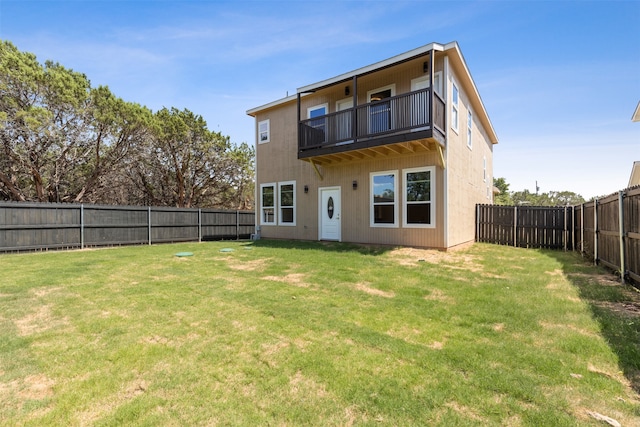 back of property with a balcony and a yard