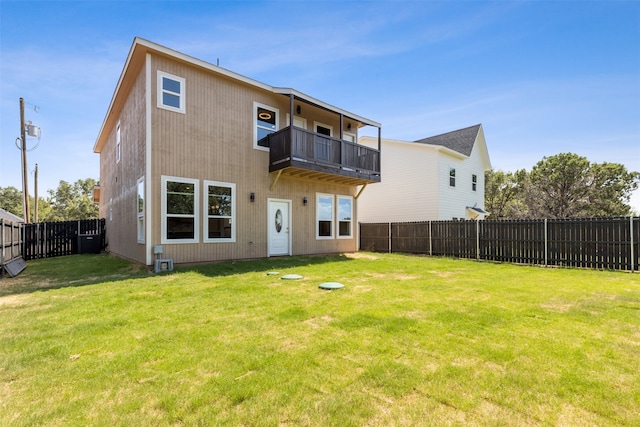 rear view of property featuring a yard and a balcony