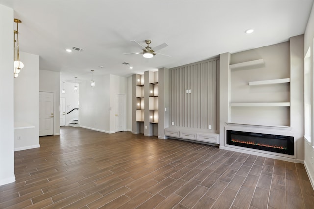 unfurnished living room with dark wood-type flooring and ceiling fan