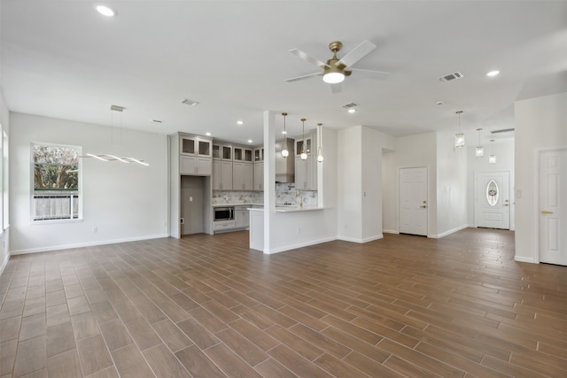 unfurnished living room with ceiling fan and hardwood / wood-style floors