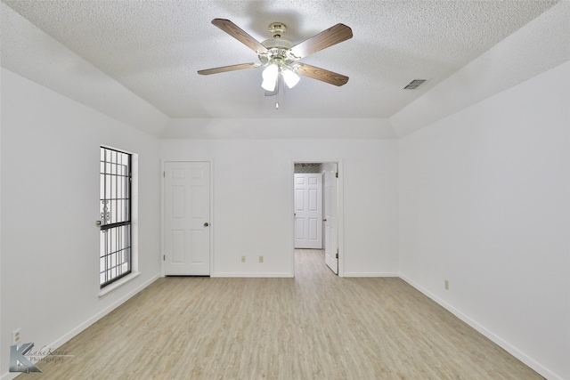 empty room with a textured ceiling, ceiling fan, and light hardwood / wood-style floors