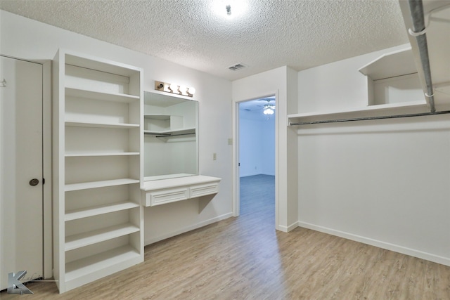 walk in closet featuring ceiling fan and light hardwood / wood-style floors