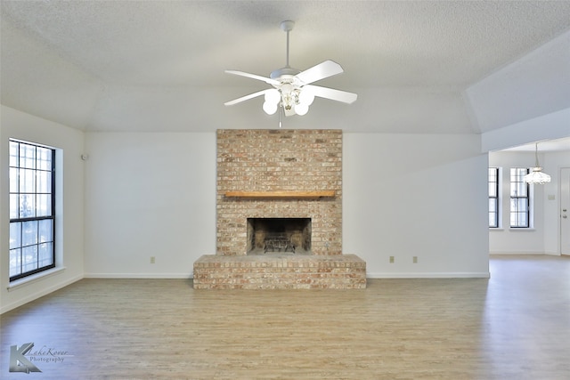 unfurnished living room with hardwood / wood-style floors, a fireplace, and plenty of natural light