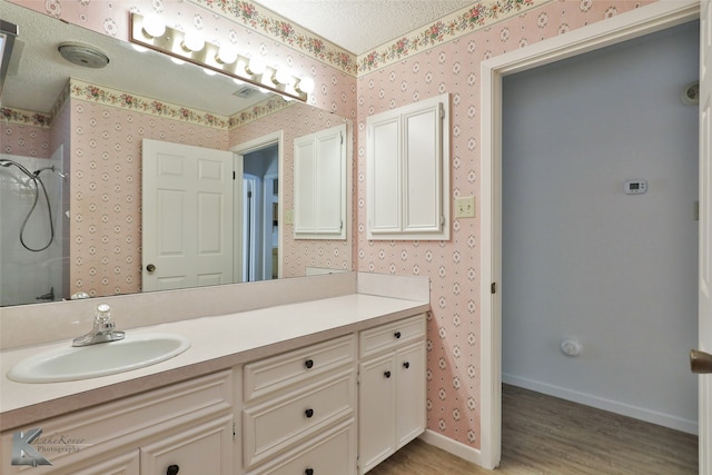 bathroom with vanity, a textured ceiling, and hardwood / wood-style floors