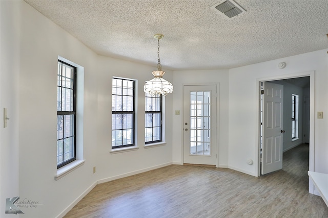 unfurnished room with wood-type flooring and a textured ceiling