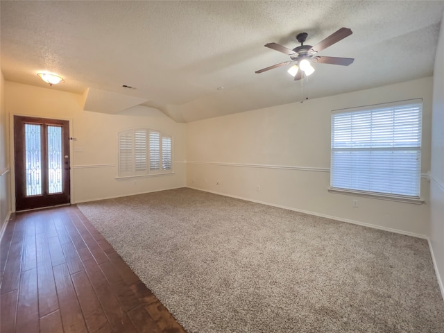 carpeted empty room featuring ceiling fan, a textured ceiling, and plenty of natural light