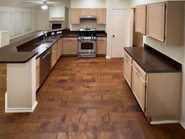 kitchen featuring dark hardwood / wood-style flooring, appliances with stainless steel finishes, ceiling fan, sink, and kitchen peninsula