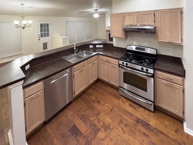 kitchen with ceiling fan with notable chandelier, appliances with stainless steel finishes, sink, decorative light fixtures, and dark hardwood / wood-style flooring