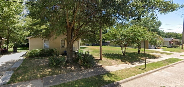 view of property hidden behind natural elements with a front lawn