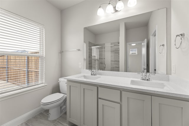 bathroom with vanity, a shower with door, and toilet