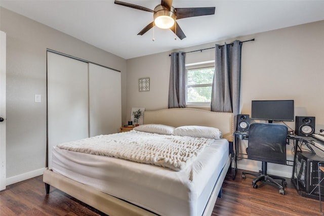 bedroom with dark wood-type flooring, ceiling fan, and a closet