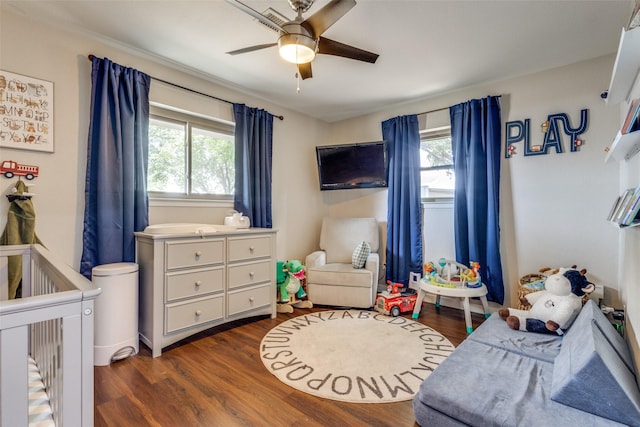 bedroom featuring dark wood-type flooring, ceiling fan, and multiple windows