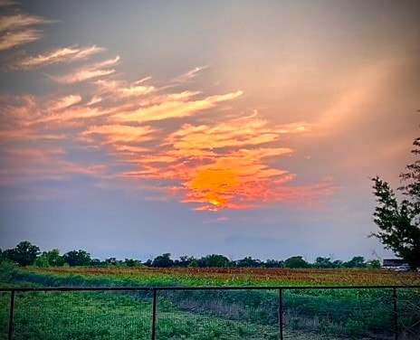 yard at dusk featuring a rural view