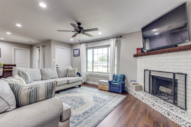 living room with a fireplace, dark hardwood / wood-style flooring, and ceiling fan