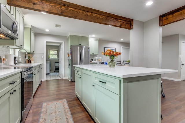 kitchen with appliances with stainless steel finishes, tasteful backsplash, dark hardwood / wood-style flooring, a center island, and green cabinets