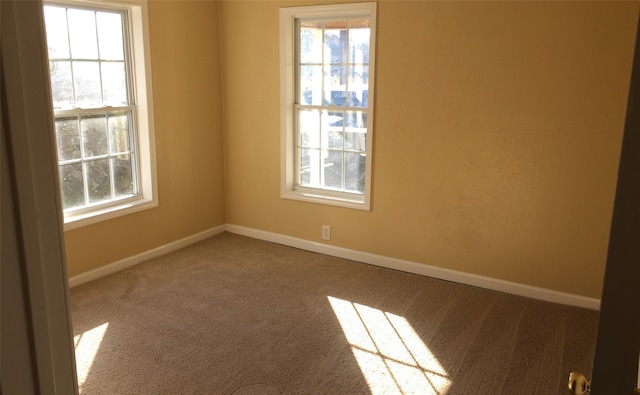 carpeted spare room with a healthy amount of sunlight