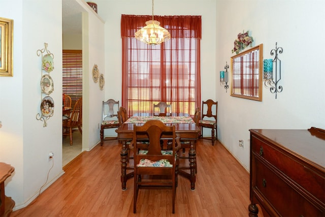 dining area featuring light wood-type flooring and a chandelier