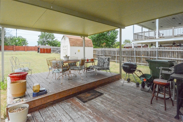 wooden deck with a lawn and a shed