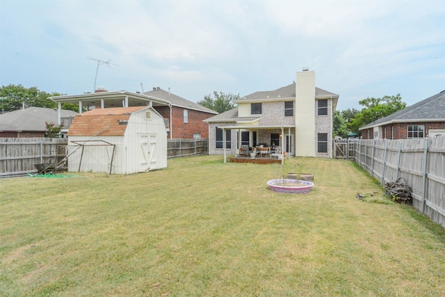 rear view of house featuring a lawn and a storage shed