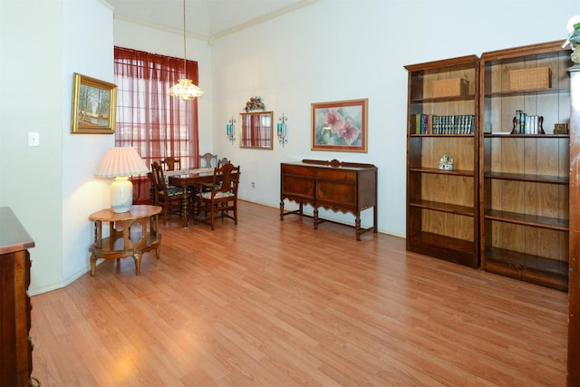 sitting room with crown molding, hardwood / wood-style floors, and an inviting chandelier