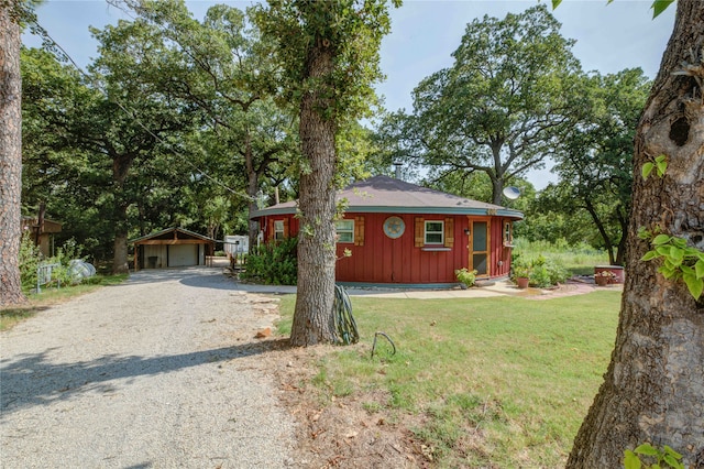 ranch-style home featuring a garage, an outdoor structure, and a front yard