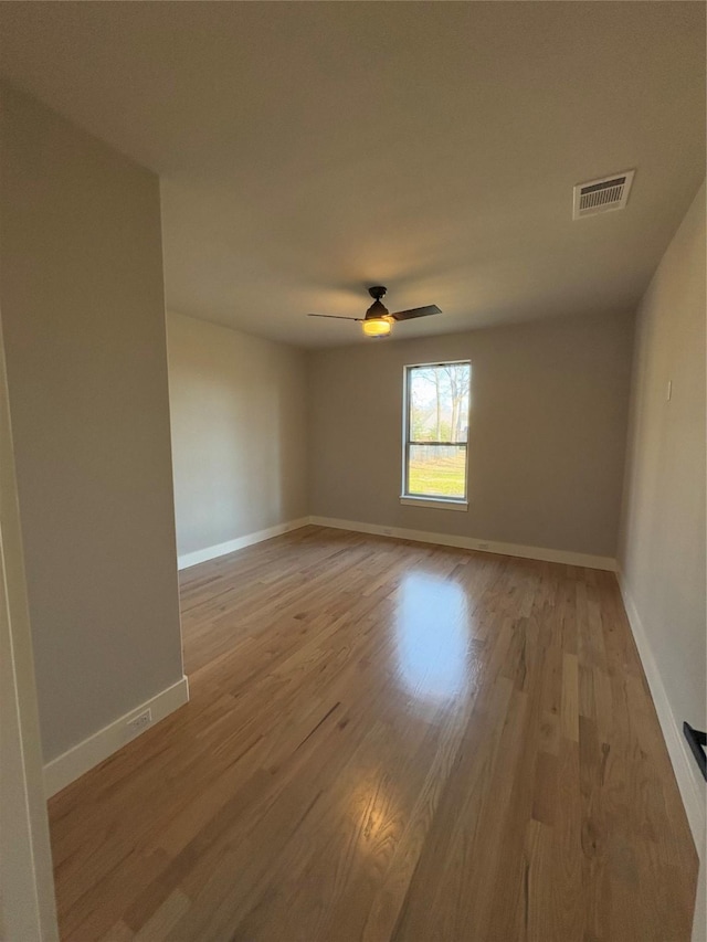 empty room with ceiling fan and light hardwood / wood-style floors