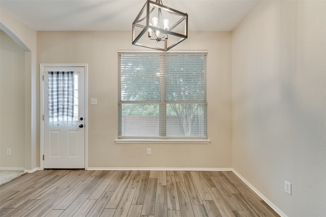 interior space with light hardwood / wood-style floors and a chandelier