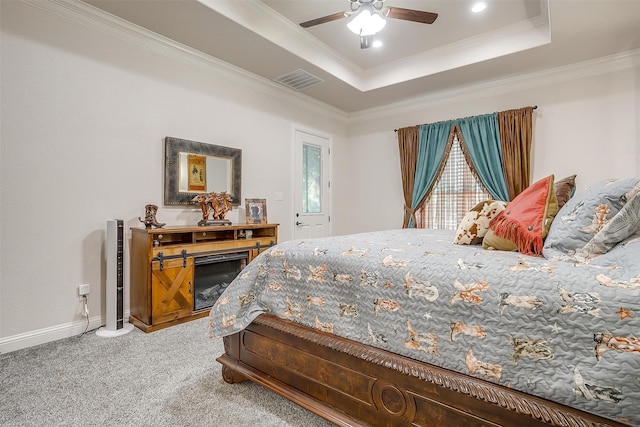 bedroom with ceiling fan, carpet floors, a tray ceiling, and ornamental molding