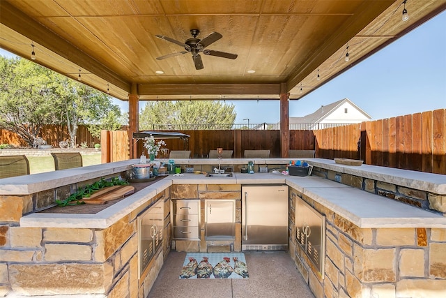 view of patio with sink, ceiling fan, and an outdoor kitchen