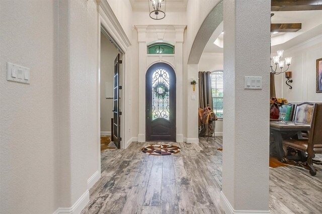 entryway with ornamental molding and hardwood / wood-style flooring