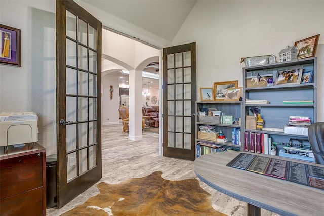 office space featuring light hardwood / wood-style floors, vaulted ceiling, and french doors